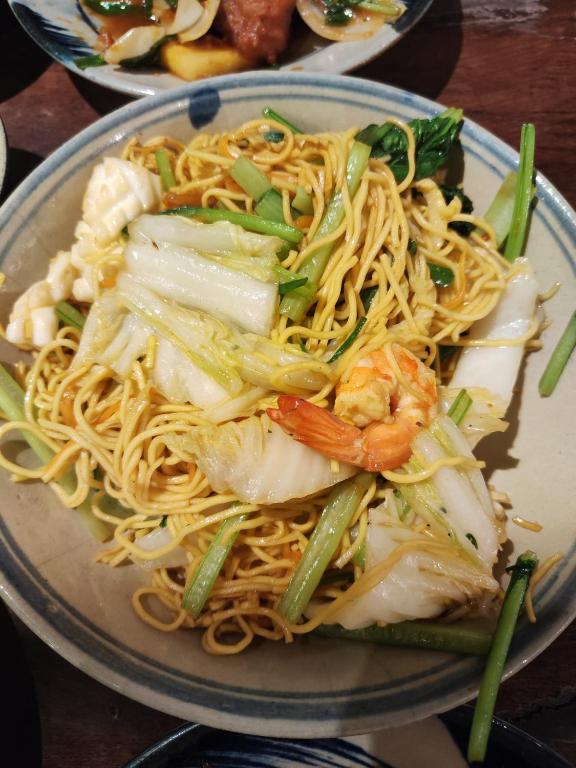 a plate of food with noodles and shrimp on it at Rose Merry Guesthouse in Bikaner
