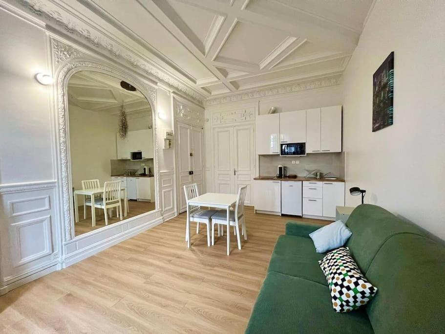 un salon avec un canapé vert et une table dans l'établissement Le Boudoir - Proche Paris - 20MC, à Chatou