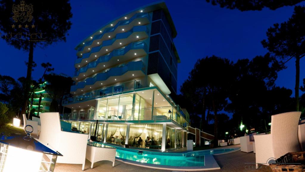 a large building with glass windows at night at Hotel Kent in Milano Marittima