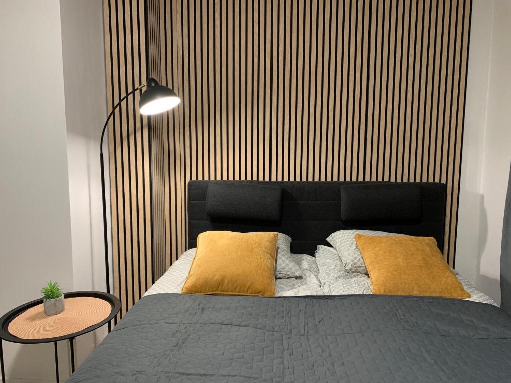 a bedroom with a bed and a wooden wall at 1BR CityApartment SY5, free parking on the street in Oulu