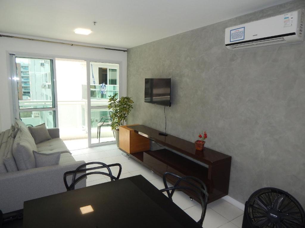 a living room with a couch and a tv at Charmoso e confortável 1 quarto/frente Mar - Mandai / Inicio da praia do Forte - CF07 in Cabo Frio