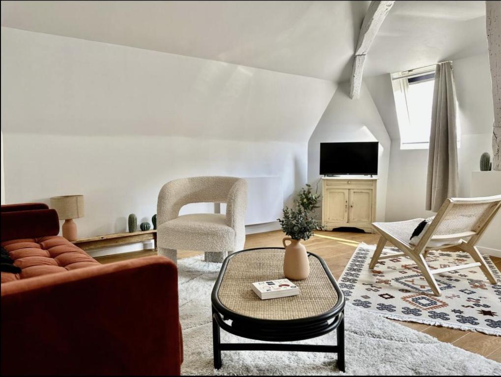 un salon avec un canapé, des chaises et une télévision dans l'établissement Eucalyptus - Reims, à Reims