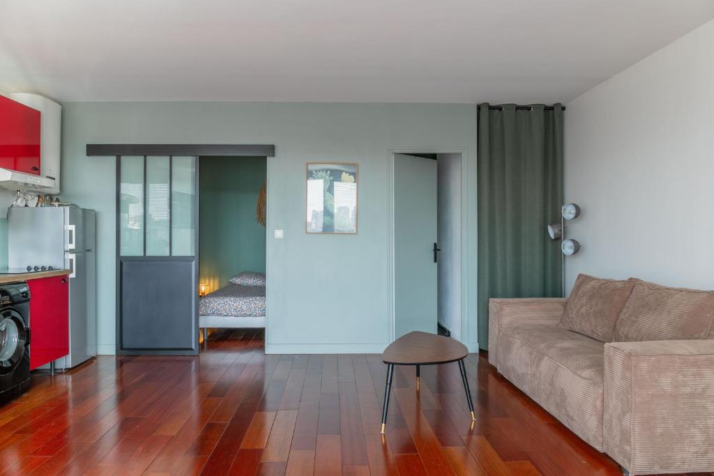 una sala de estar con un sofá y una mesa en Bel appartement F2 42 m2, en Ivry-sur-Seine