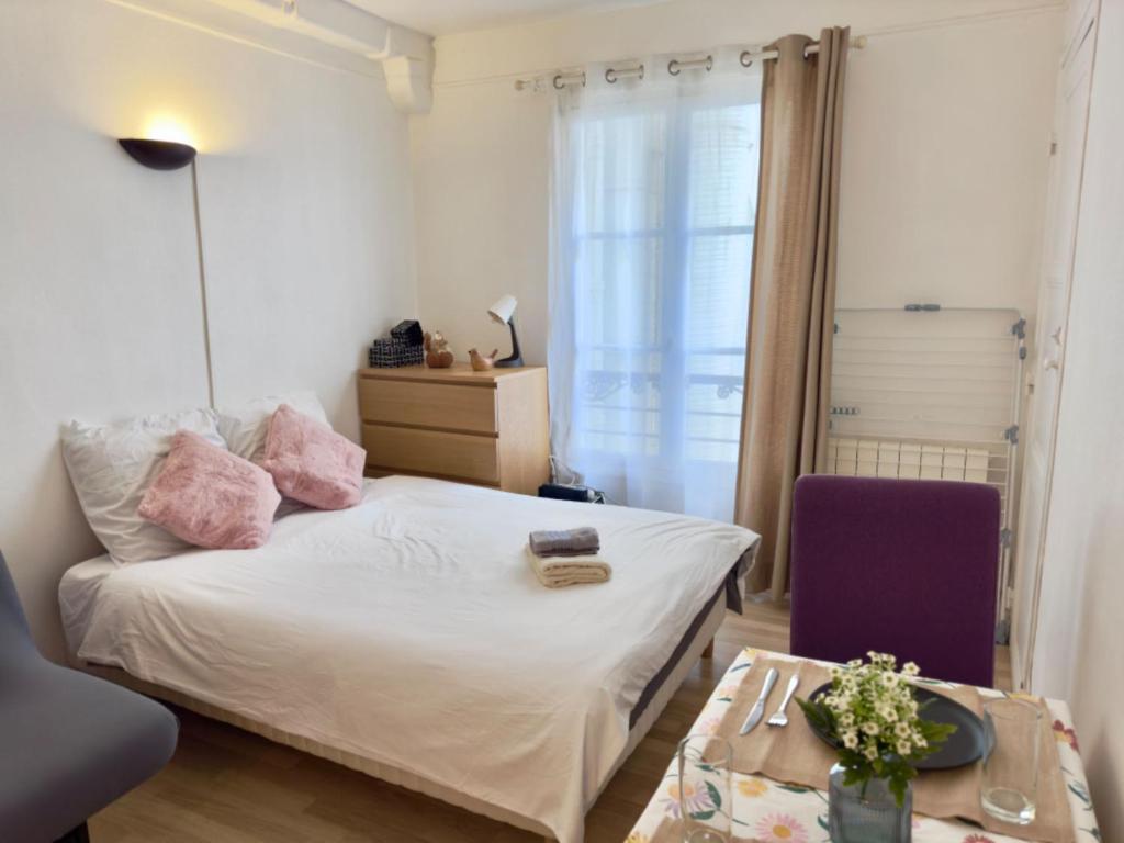 une petite chambre avec un lit et une table dans l'établissement Devenez voisin du Président, à Paris
