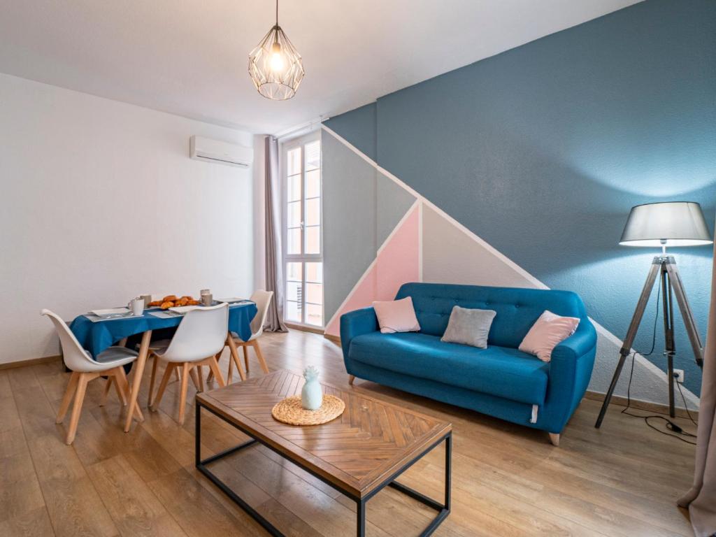 un salon avec un canapé bleu et une table dans l'établissement Le NidCatalan - Centre-Ville - 4 pers, à Perpignan