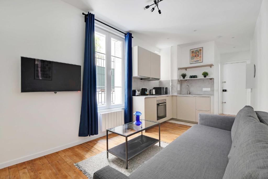 un salon avec un canapé et une table dans l'établissement Charming apartment -1BR-4P- Gare Montparnasse, à Paris