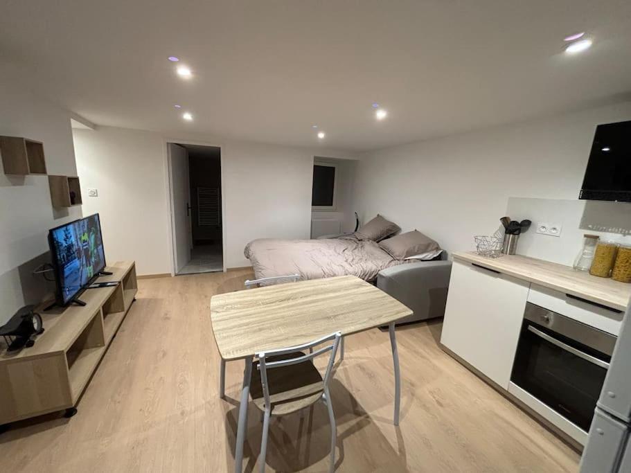 un salon avec un lit et une table et une cuisine dans l'établissement Studio au cœur de Millau, à Millau