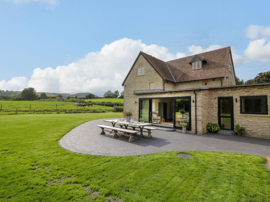 Una casa con una mesa de picnic delante de ella. en Grove Farm, en Church Stretton