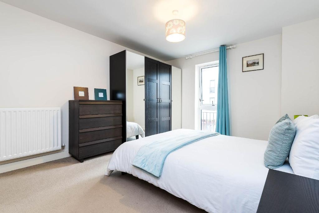 ロンドンにあるGreenwich Houseのベッドルーム1室(ベッド1台、ドレッサー、窓付)