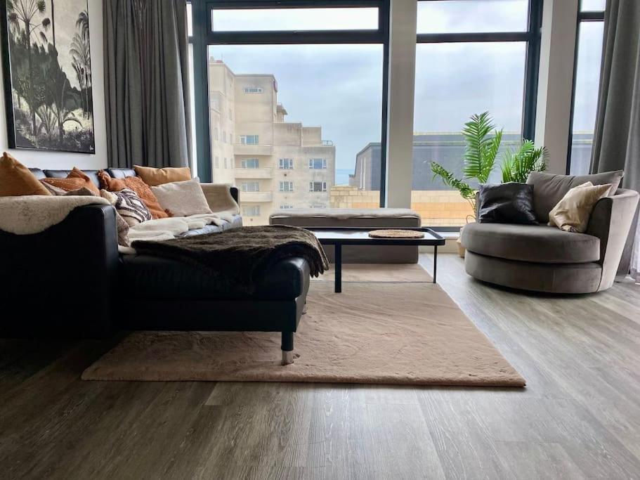 a living room with two couches and a large window at THE PAD by the beach Penthouse apartment with sunset and city views in Bournemouth