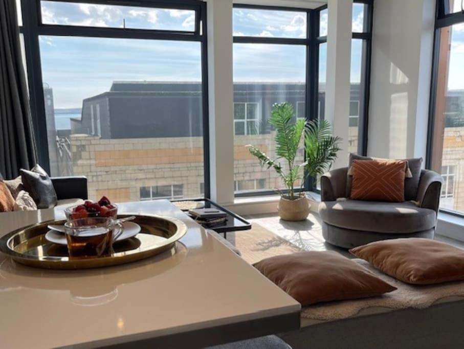 a living room with a view of a building at THE PAD by the beach Penthouse apartment with sunset and city views in Bournemouth
