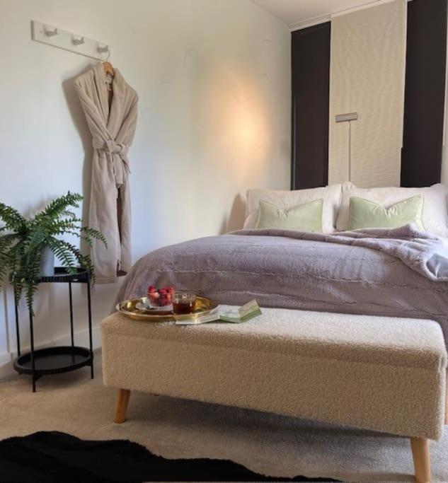 a bedroom with a bed with a tray on a table at THE PAD by the beach Penthouse apartment with sunset and city views in Bournemouth