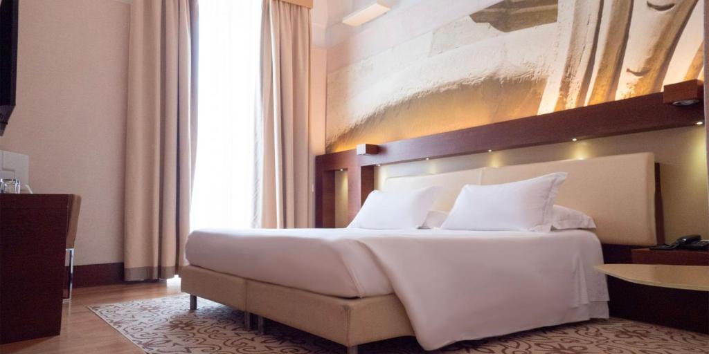 A bed or beds in a room at Risorgimento Resort