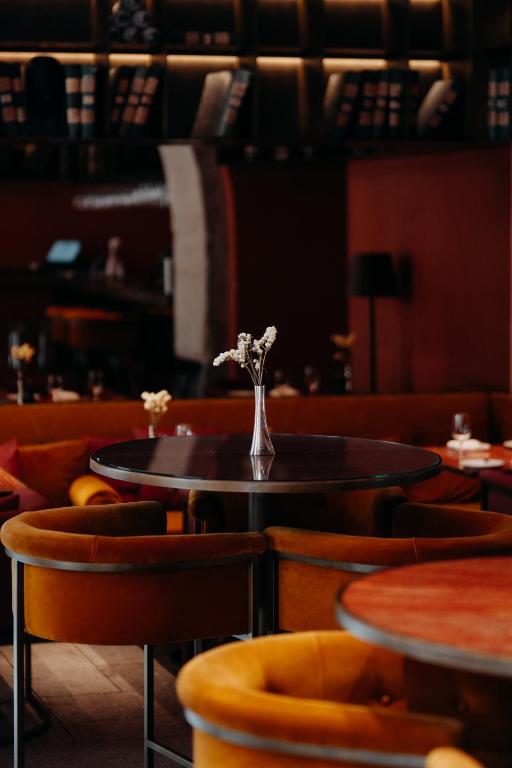 a table and chairs with a vase of flowers on it at Casa da Companhia, Vignette Collection by IHG in Porto
