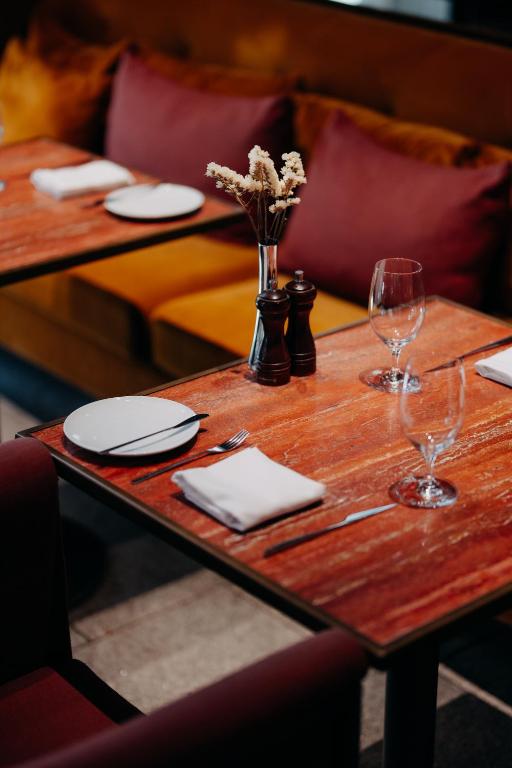 a wooden table with plates and wine glasses on it at Casa da Companhia, Vignette Collection by IHG in Porto