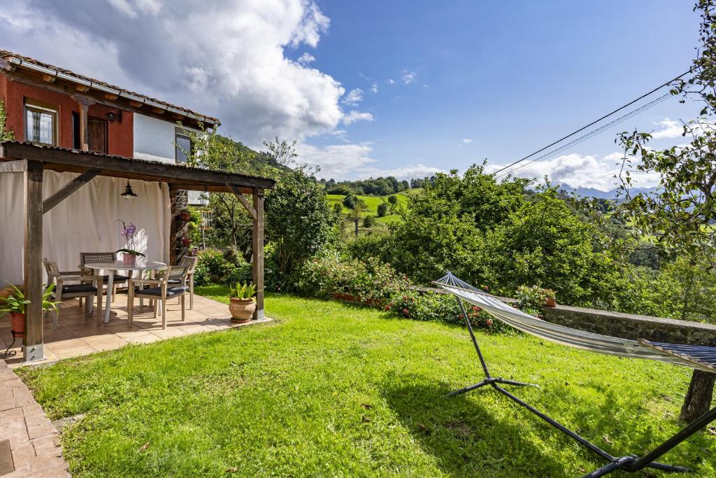 a garden with a hammock in the yard of a house at La Casita de Heidi in Cangas de Onís