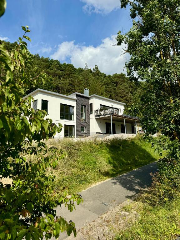 a large white house on top of a hill at Wohnung am Wald in Geisa
