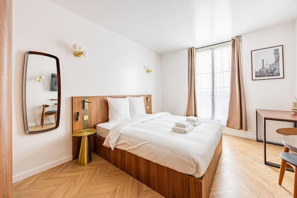une chambre avec un grand lit et un miroir dans l'établissement 152 Suite luxueuse-Etienne Marcel-Châtelet-Paris 3, à Paris