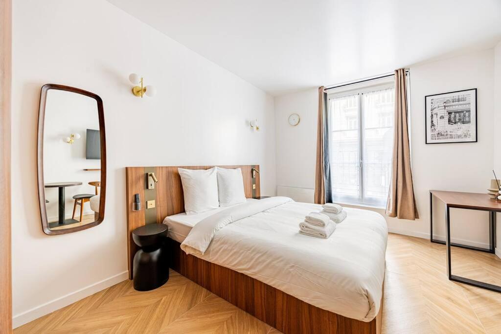 une chambre avec un grand lit et un miroir dans l'établissement 151 Suite luxueuse-Etienne Marcel-Châtelet-Paris 3, à Paris