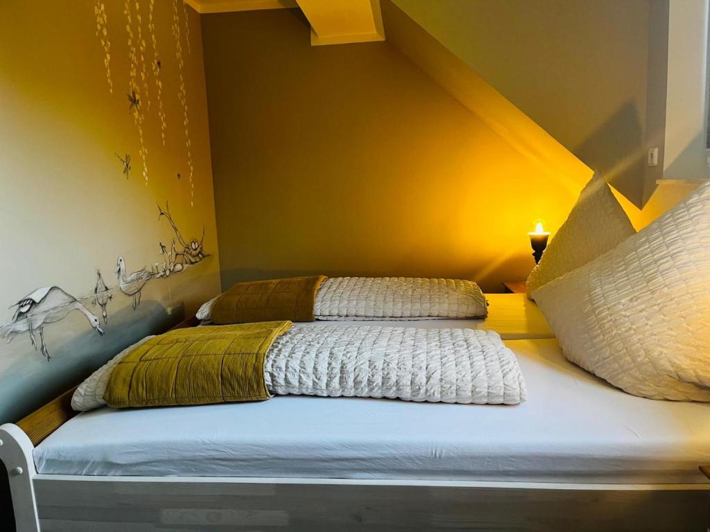 ein Bett mit zwei Kissen in einem Zimmer in der Unterkunft Ferienwohnung Zur Alten Tischlerei in Dissen