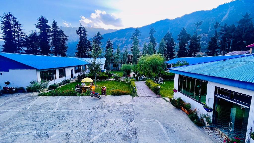 an aerial view of a building with a yard and a house at Relax Cottages & Resort Kalam in Kalām