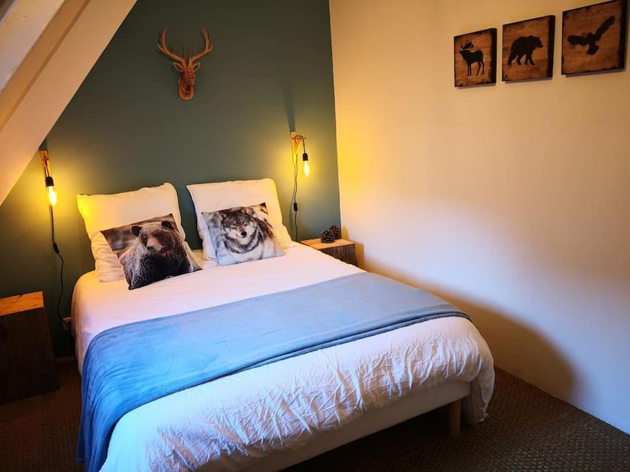 a bedroom with a bed with two dogs on the pillows at ESTRELIAS - maison de vacances - Cauterets centre in Cauterets