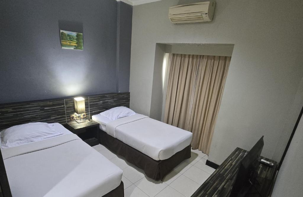 Postel nebo postele na pokoji v ubytování N2 Hotel Gunung Sahari