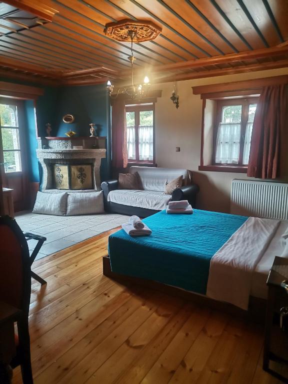 Un dormitorio con una cama grande y un sofá. en Konstantinou & Elenis, en Monodendri