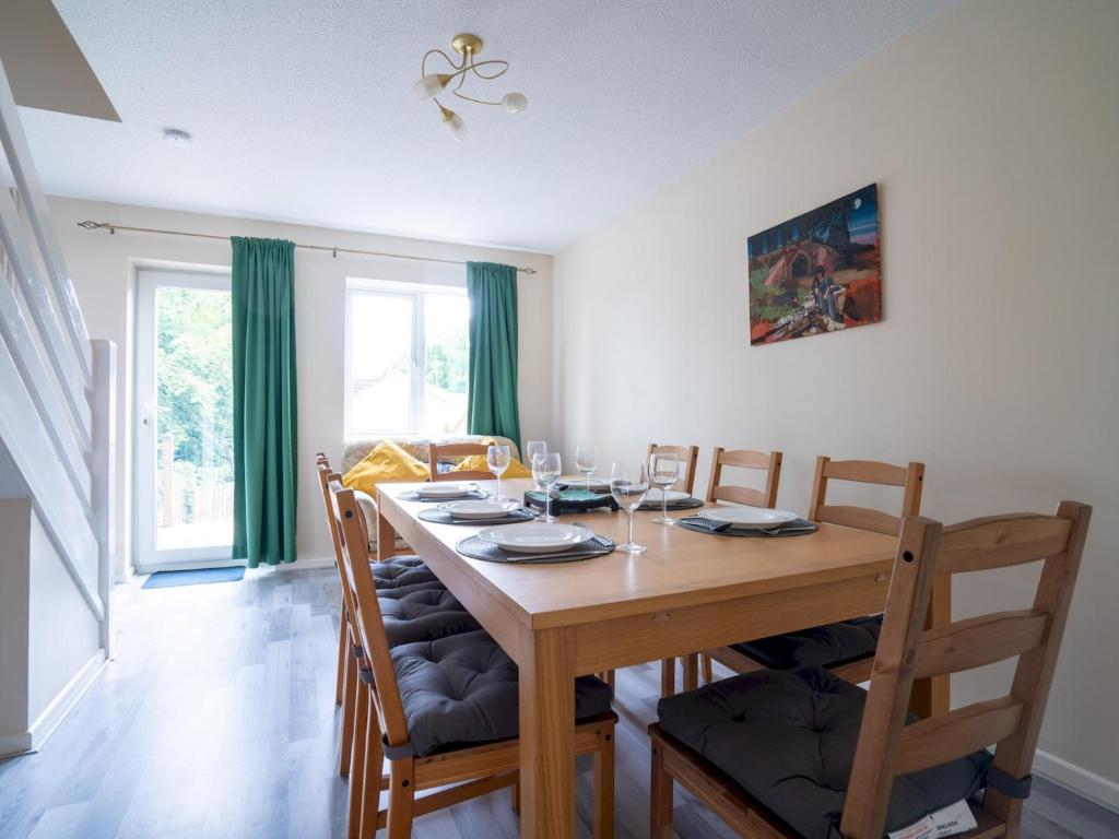 a dining room with a wooden table and chairs at 3 Bedroom family home Parking Garden - Pass the Keys in Stroud