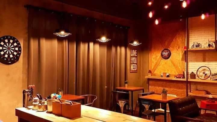 een restaurant met een bar met tafels en stoelen bij 約旦河民宿包棟附電動麻將 in Hsia-ch'ing