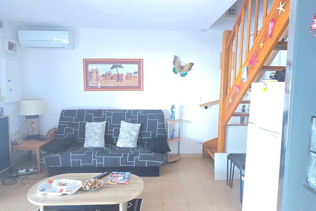 un salon avec un canapé et une table dans l'établissement La Malou, à Portiragnes