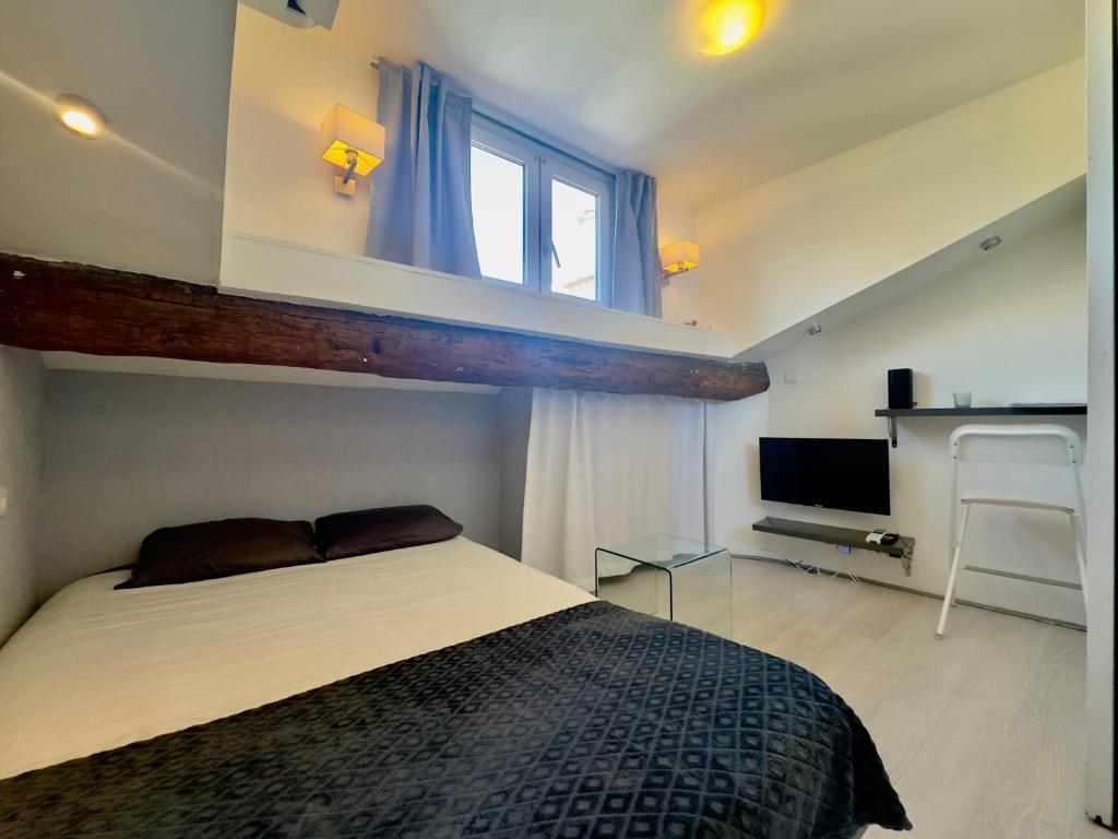 sypialnia z łóżkiem, oknem i telewizorem w obiekcie Mini Studio - Le Chabaud - Cannes centre w Cannes