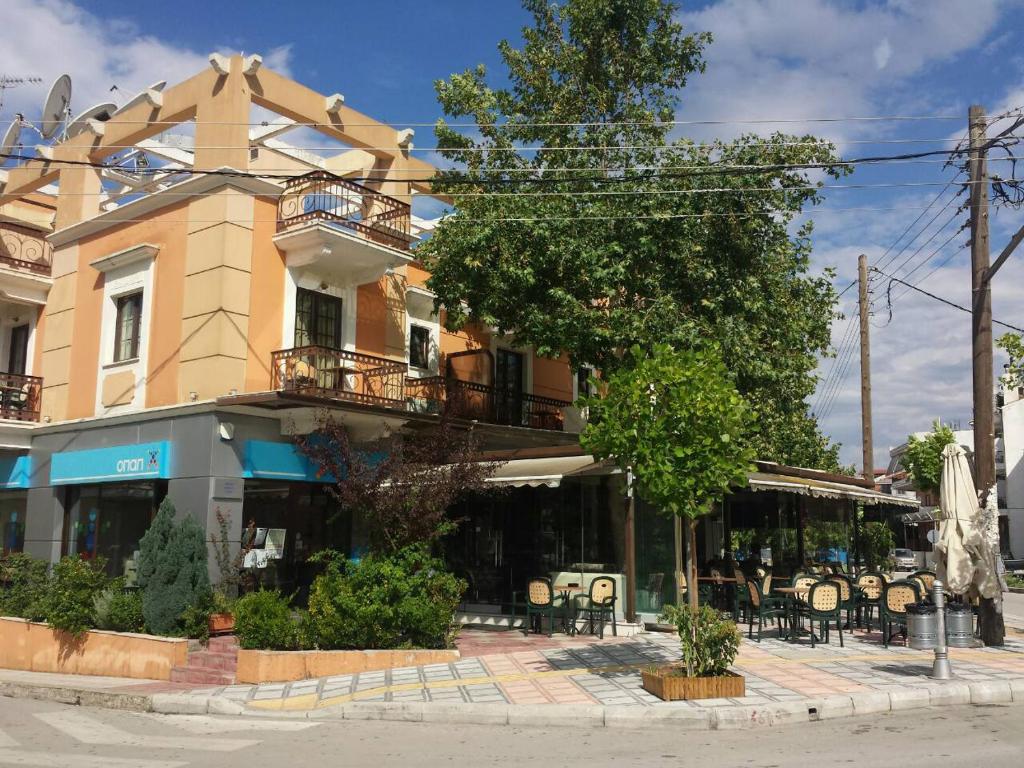 a building with tables and chairs on a city street at Yiannis Apartments in Ioannina