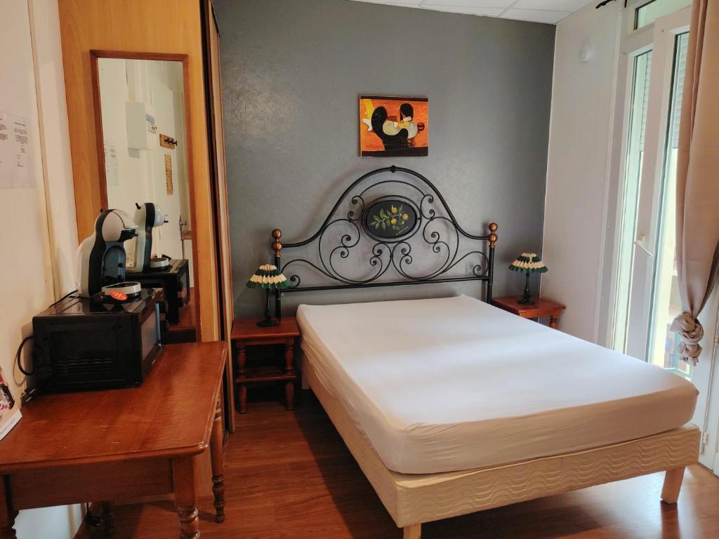 une chambre avec un lit, une table et un miroir dans l'établissement Studio N2 Appartement Hôtel Combes, à Amélie-les-Bains-Palalda