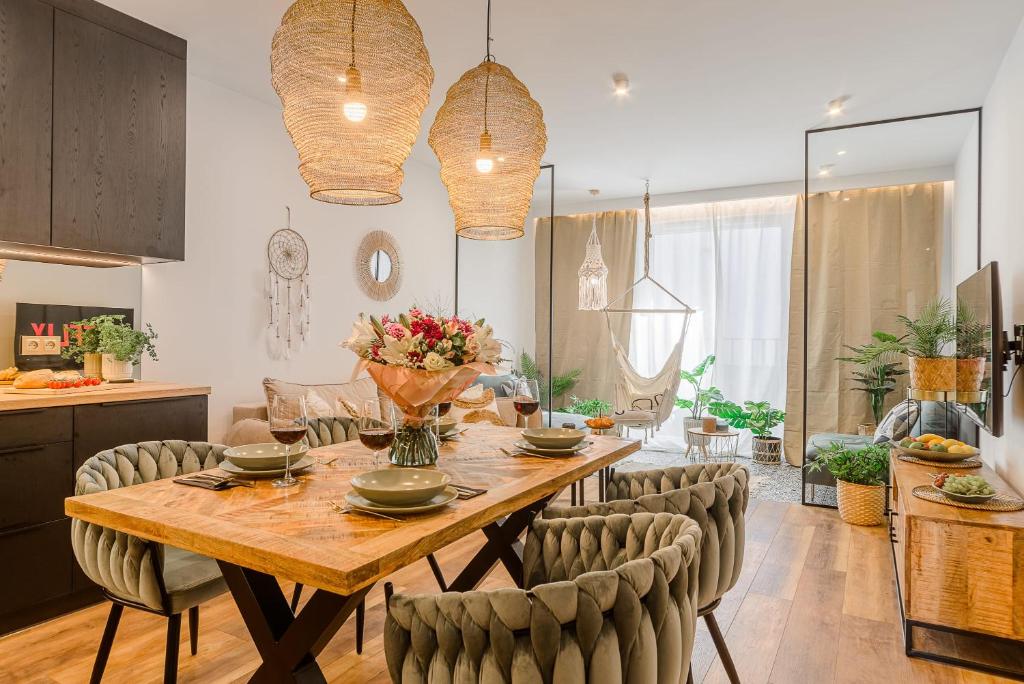 a kitchen and dining room with a wooden table and chairs at Lumina I Premium 3-room Apartments with Parking I Balcony I Manufaktura in Łódź
