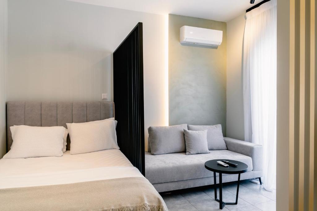 a bedroom with a bed and a couch at Urban Gem-Fresh & Central in Alexandroupoli