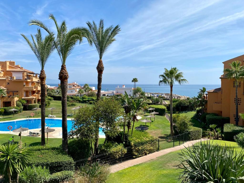 Blick auf ein Resort mit Palmen und das Meer in der Unterkunft Los Granados de la Duquesa in San Luis de Sabinillas