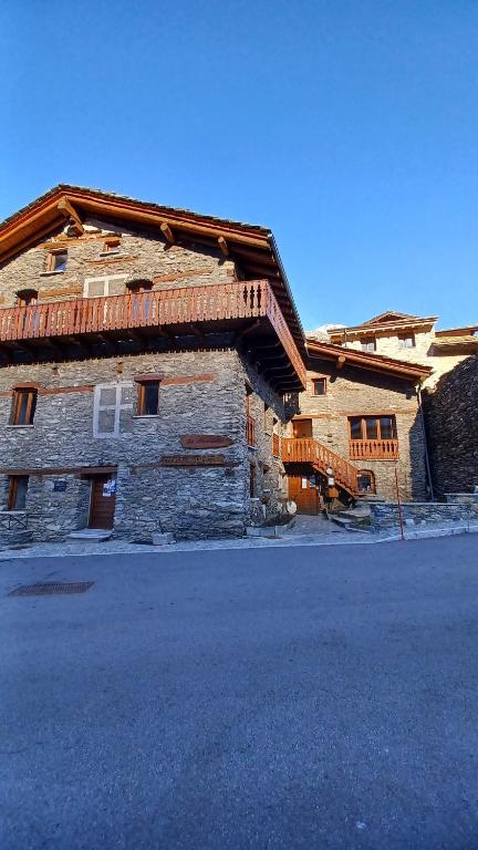 un grand bâtiment en pierre avec un toit dans l'établissement Le Chalet La Pastorale, à Val Cenis