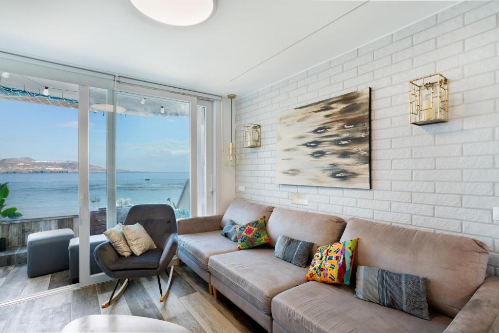 Una sala de estar con un sofá y vista al mar. en flat Belvedere las canteras beach, en Las Palmas de Gran Canaria