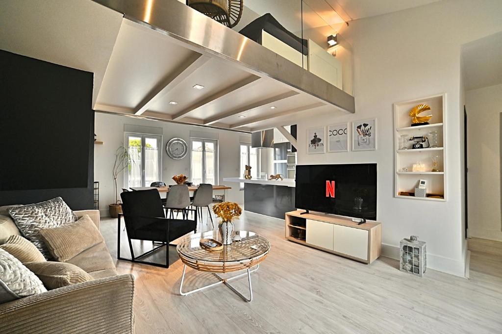 un salon avec un canapé et une table dans l'établissement Précieux - Parking Gratuit, Climatisation, Tv 4K, Fibre, Terrasse, Entièrement Rénové, à Tasdon