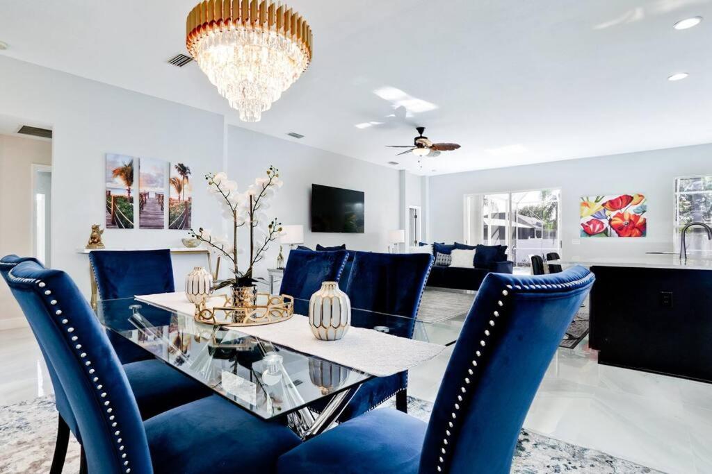 a dining room with a glass table and blue chairs at The Pool House - Private, Heated Pool in Elwood Park