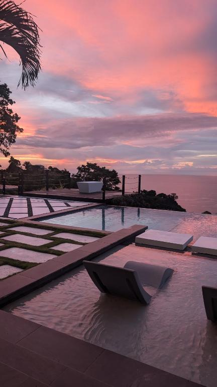 a pool of water with a sunset in the background at Silk Cotton Cottages in Parrot Hall