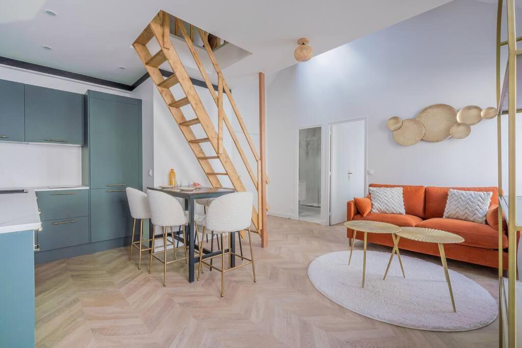 - un salon avec un canapé orange et une table dans l'établissement Appartement Mezzanine proche Atelier des lumières, à Paris