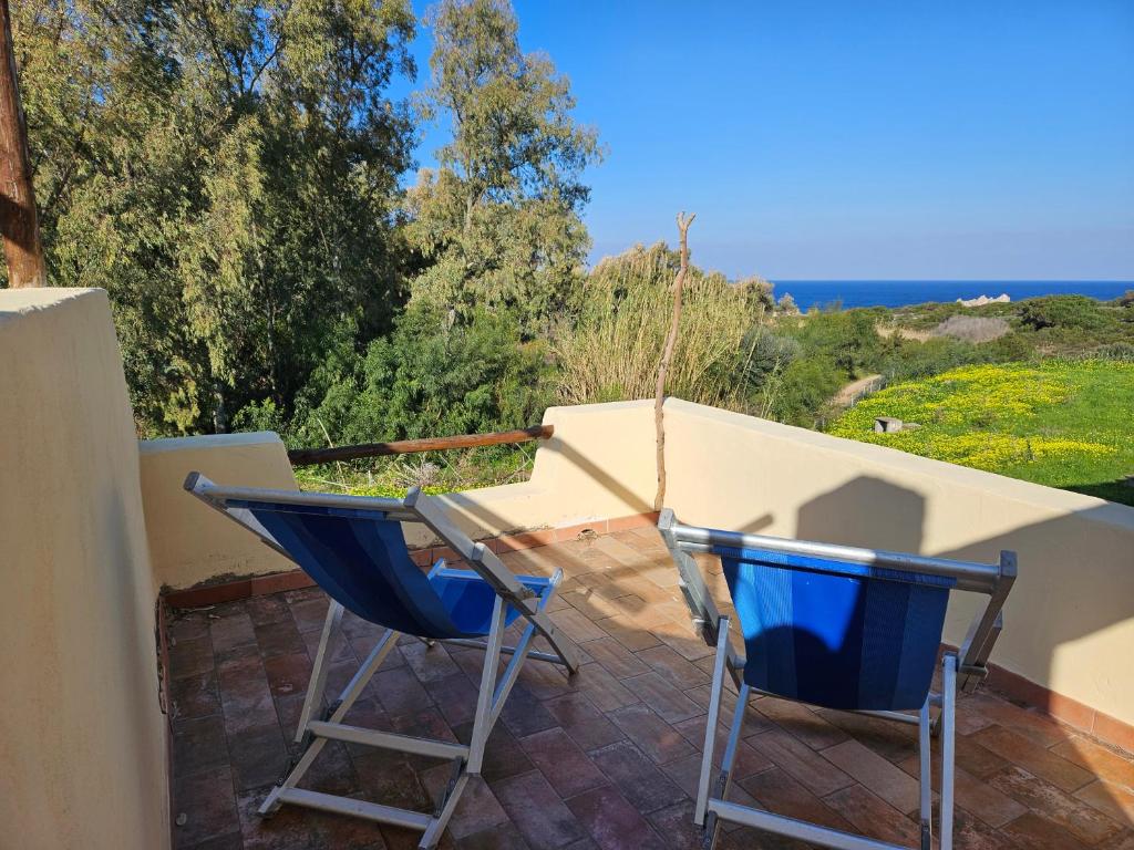 2 Stühle auf einer Terrasse mit Meerblick in der Unterkunft Casa prima fila con Vista Mare in Isola Rossa