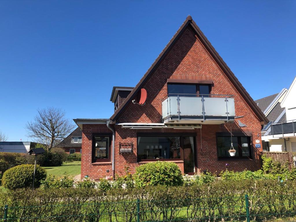 a red brick house with a balcony on top at Haus Seehunde im Büsumer Kurviertel in Büsum