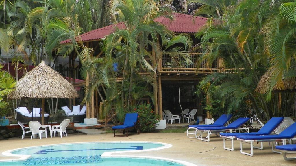 un complejo con sillas azules y piscina en Amanwana Ecofinca, en Melgar