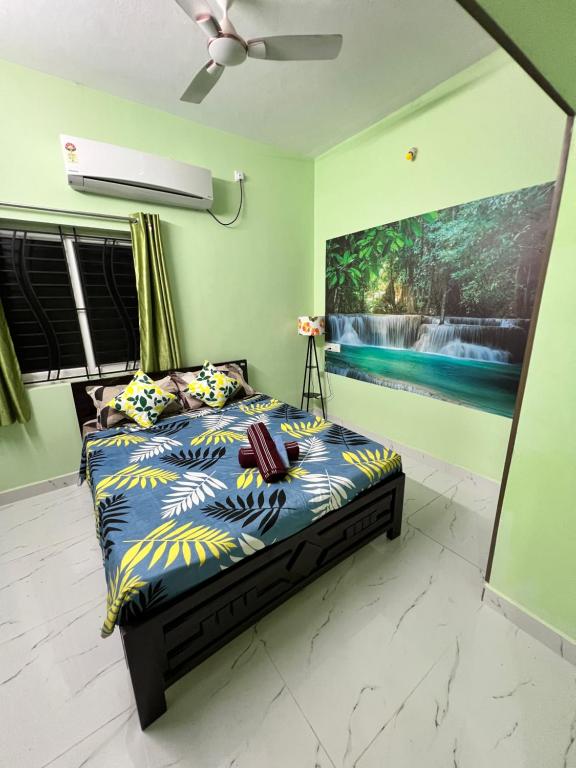 ein Schlafzimmer mit einem Bett und einem Gemälde an der Wand in der Unterkunft Sri Bairav Cottage in Madurai