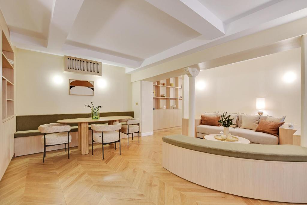 un salon avec un canapé, une table et des chaises dans l'établissement ONIRI - Serviced Apartment in Place Vendôme, à Paris