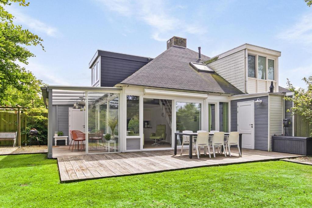 ein Haus mit einer Terrasse mit Tisch und Stühlen in der Unterkunft Vakantiewoning voor het gezin in Stavenisse in Stavenisse