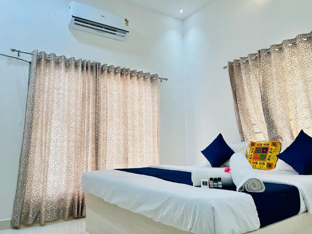 a bedroom with two beds and a window with curtains at Agariya Pool Villa near Lake pichola in Udaipur